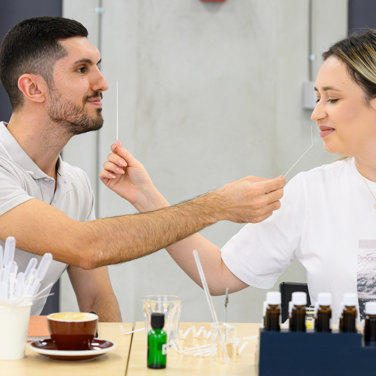 Cuplu mirosind parfumurile pe care le-au creat în cadrul unui atelier de parfumerie