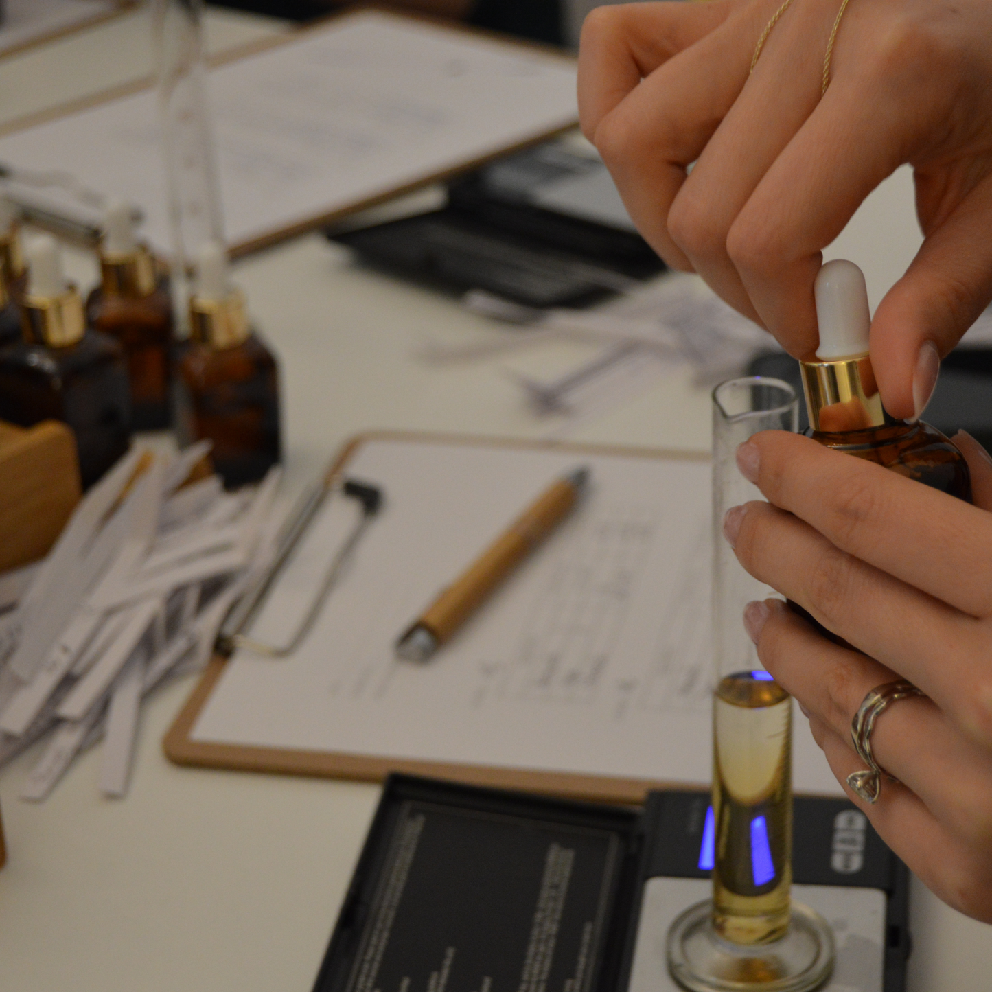 Participantă adăugând ingredientele preferate cu pipeta, în timpul unui atelier de parfumerie