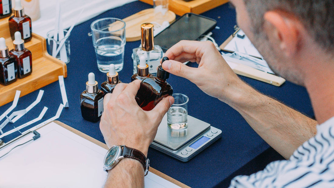 Participant la atelier de parfum deschide o sticluță cu esență deasupra paharului gradat de pe cântar