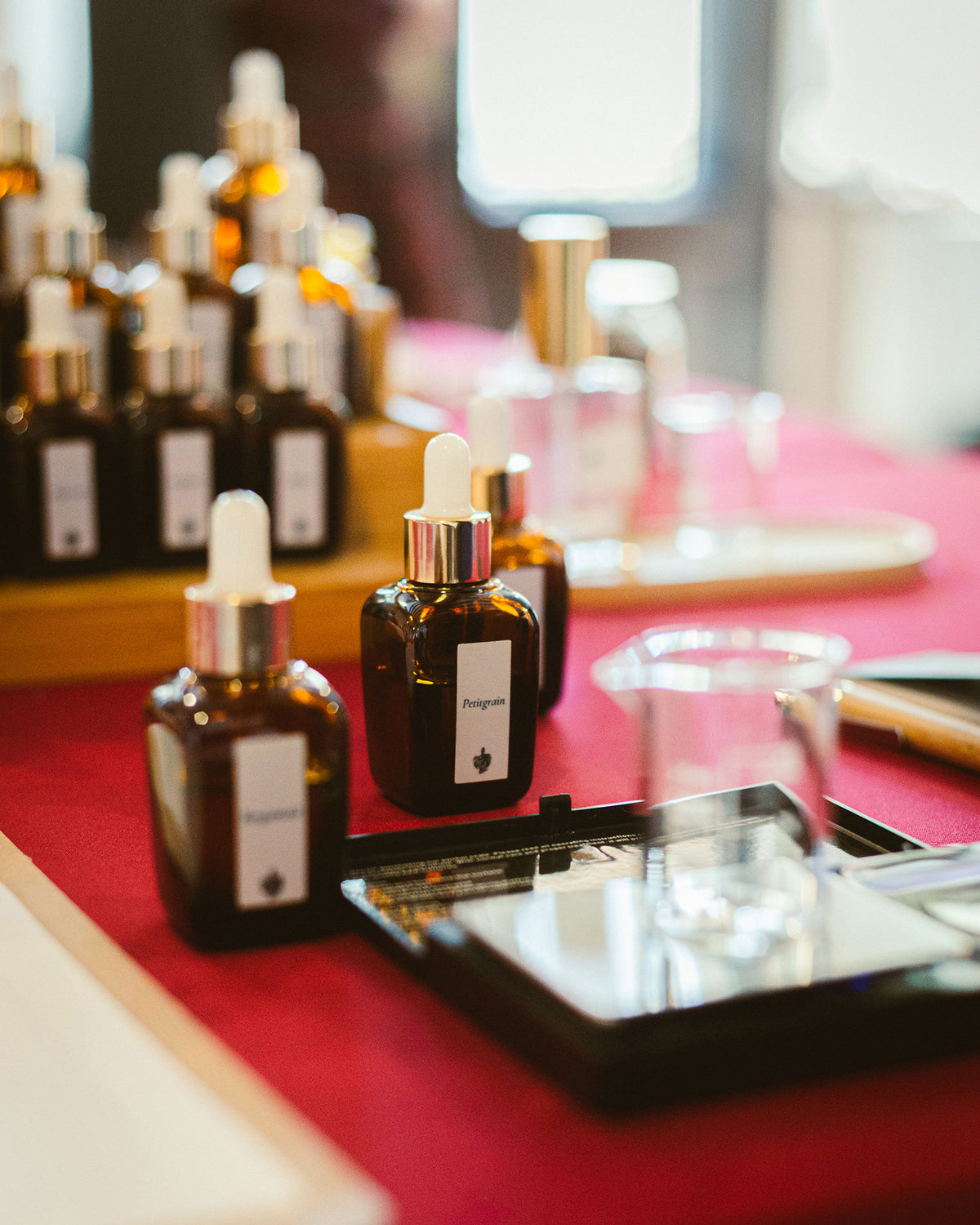 Sticluța cu esența Petitgrain lângă cântarul electronic, pe masa atelierului de parfum