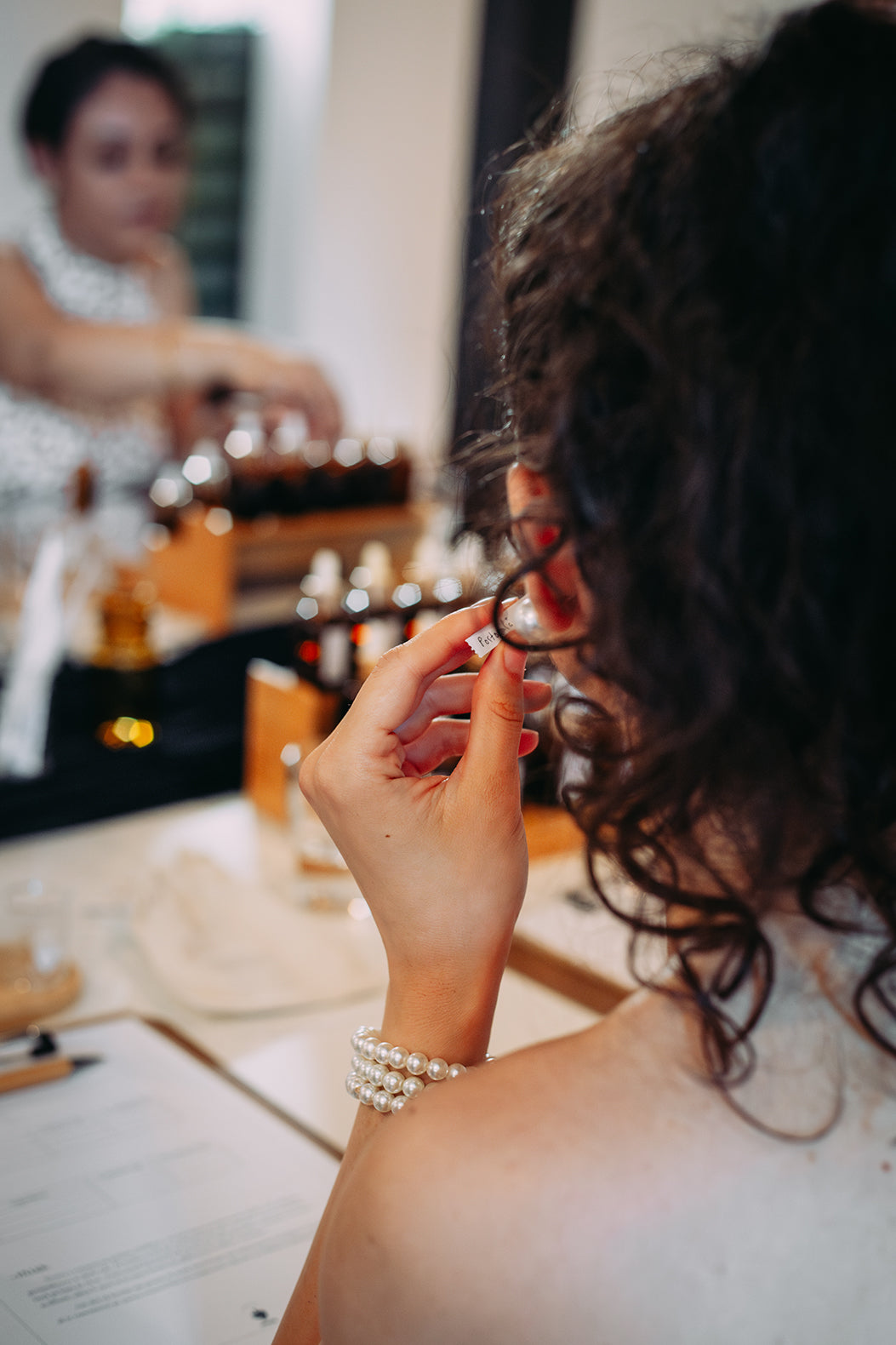 Participanta miroase un blotter etichetat la atelierul de parfum de grup susținut de Parfumeria Mura