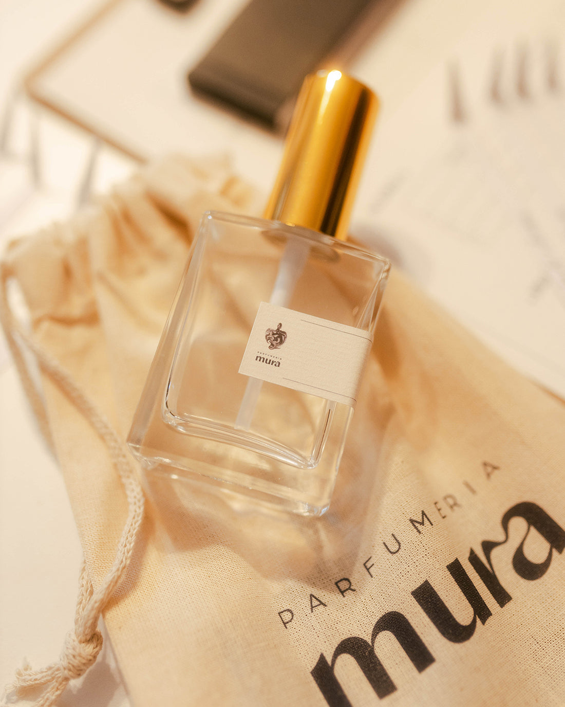 Sticluța de parfum personalizat cu pulverizator auriu și eticheta Parfumeria Mura, pe săculețul primit la atelier