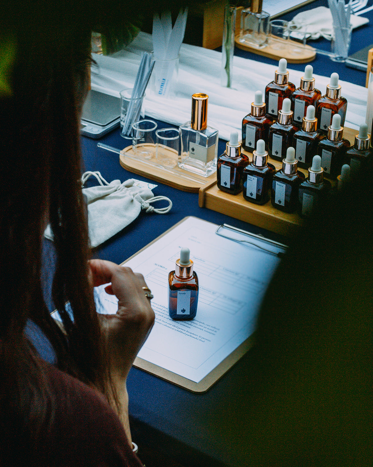 Participantă la atelier cu fișa de formulă a parfumului și sticluța acordului Acvatic în față