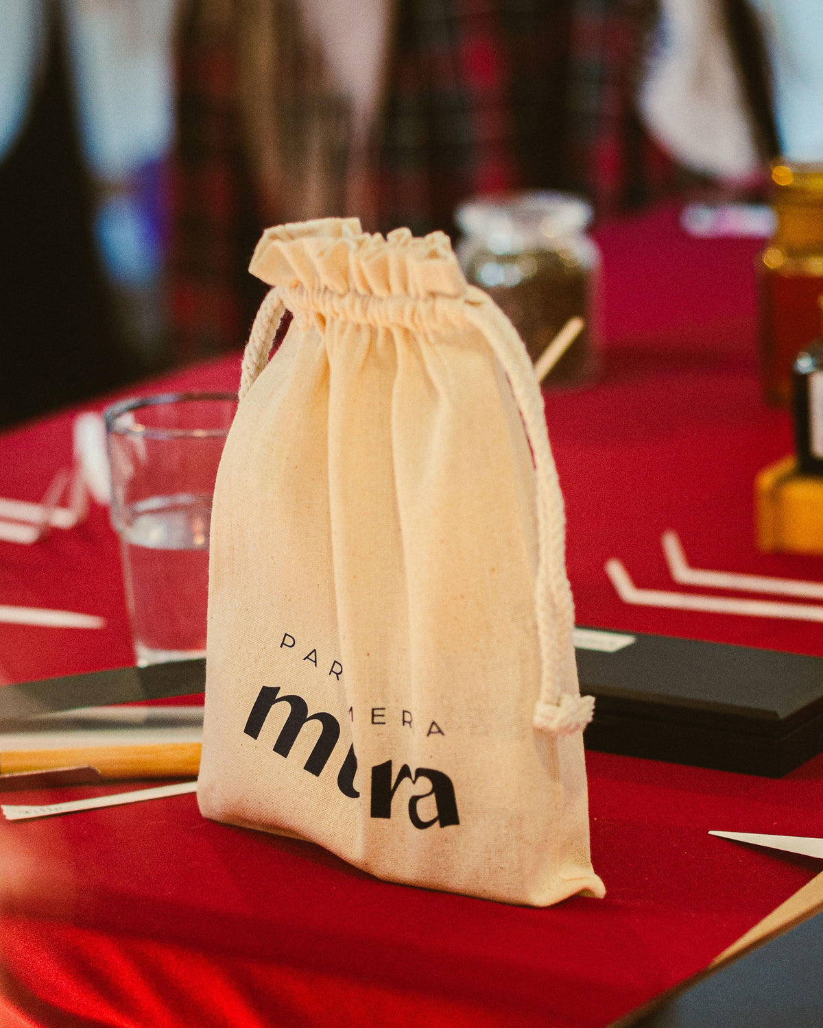 Săculeț cu logo Parfumeria Mura pe masa atelierului de parfum, primit de participant