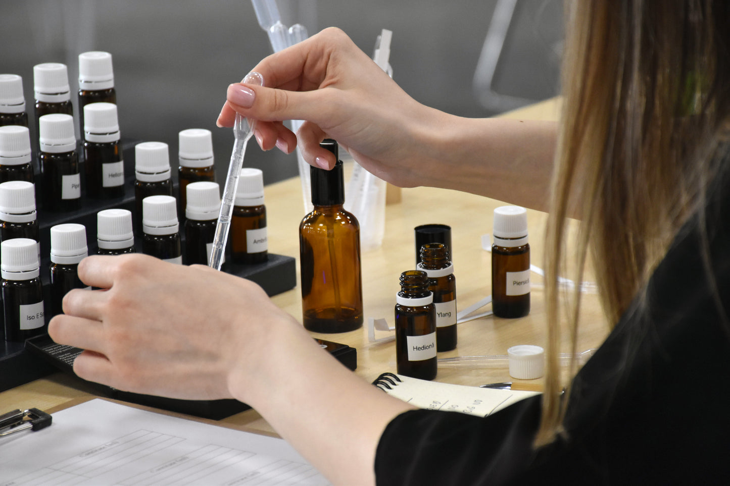 Adaugarea ingredientelor cu pipeta pentru a crea un parfum personalizat la un atelier de parfumerie individual din București